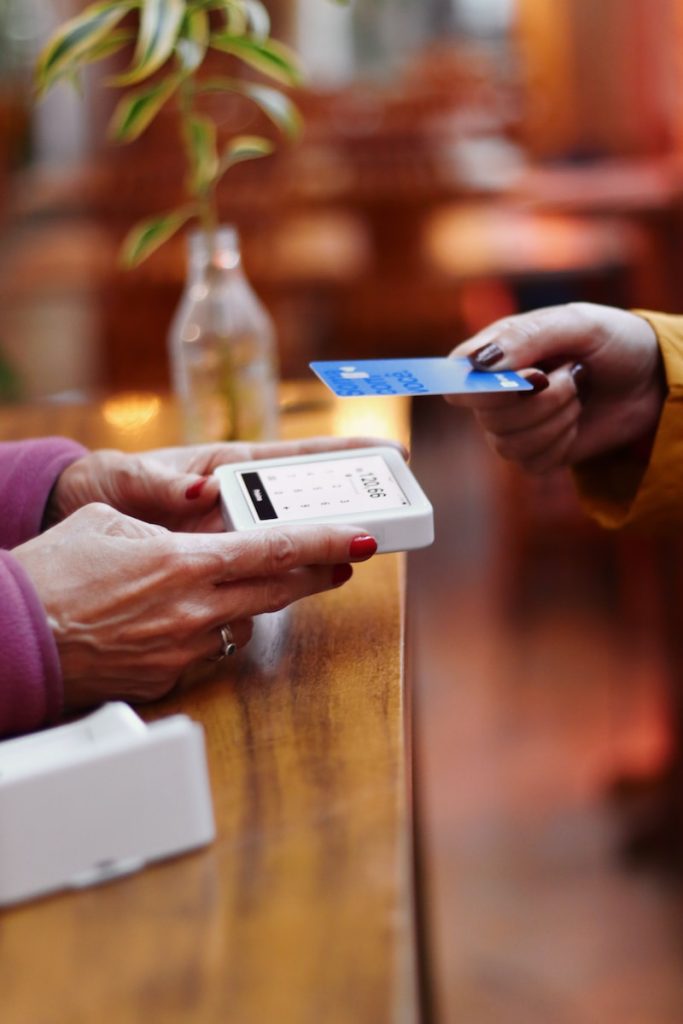 deux personnes échangeant une carte de crédit à une table