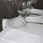man touching near empty wineglass